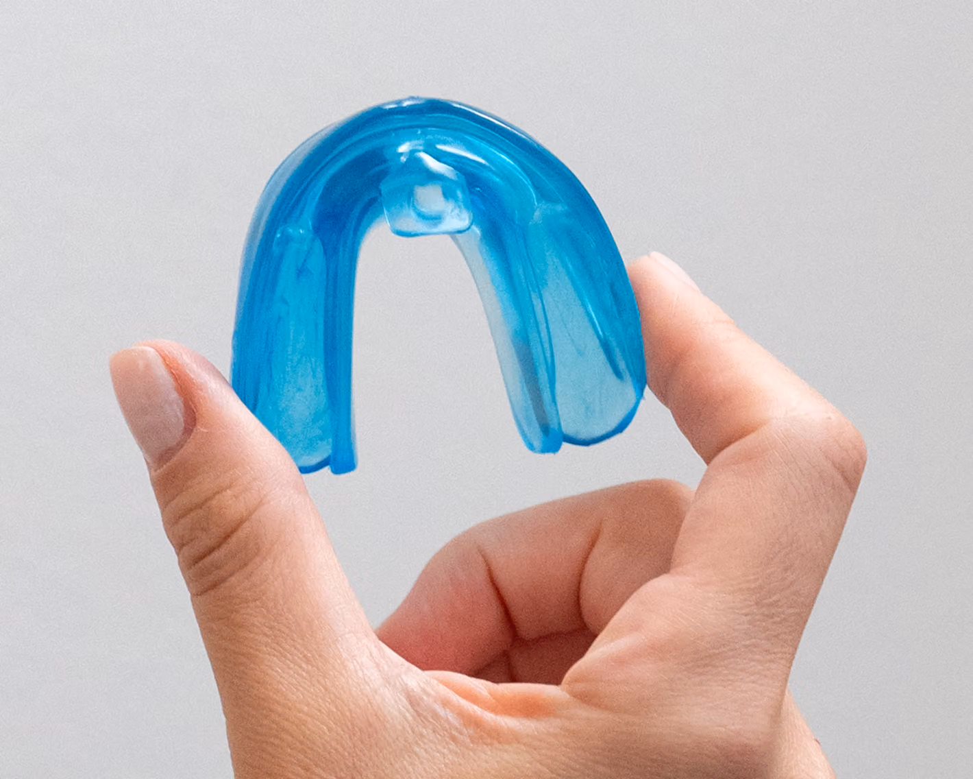 Young boy holding a blue Toothpillow oral appliance.