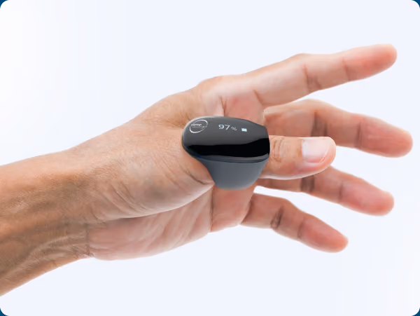 A hand holding the small black SleepImage sensor ring against a soft background.