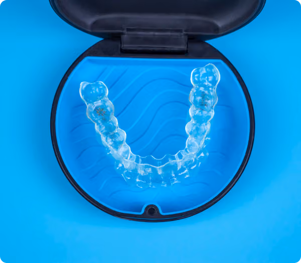 Clear retainer inside an open blue case on a bright blue background.