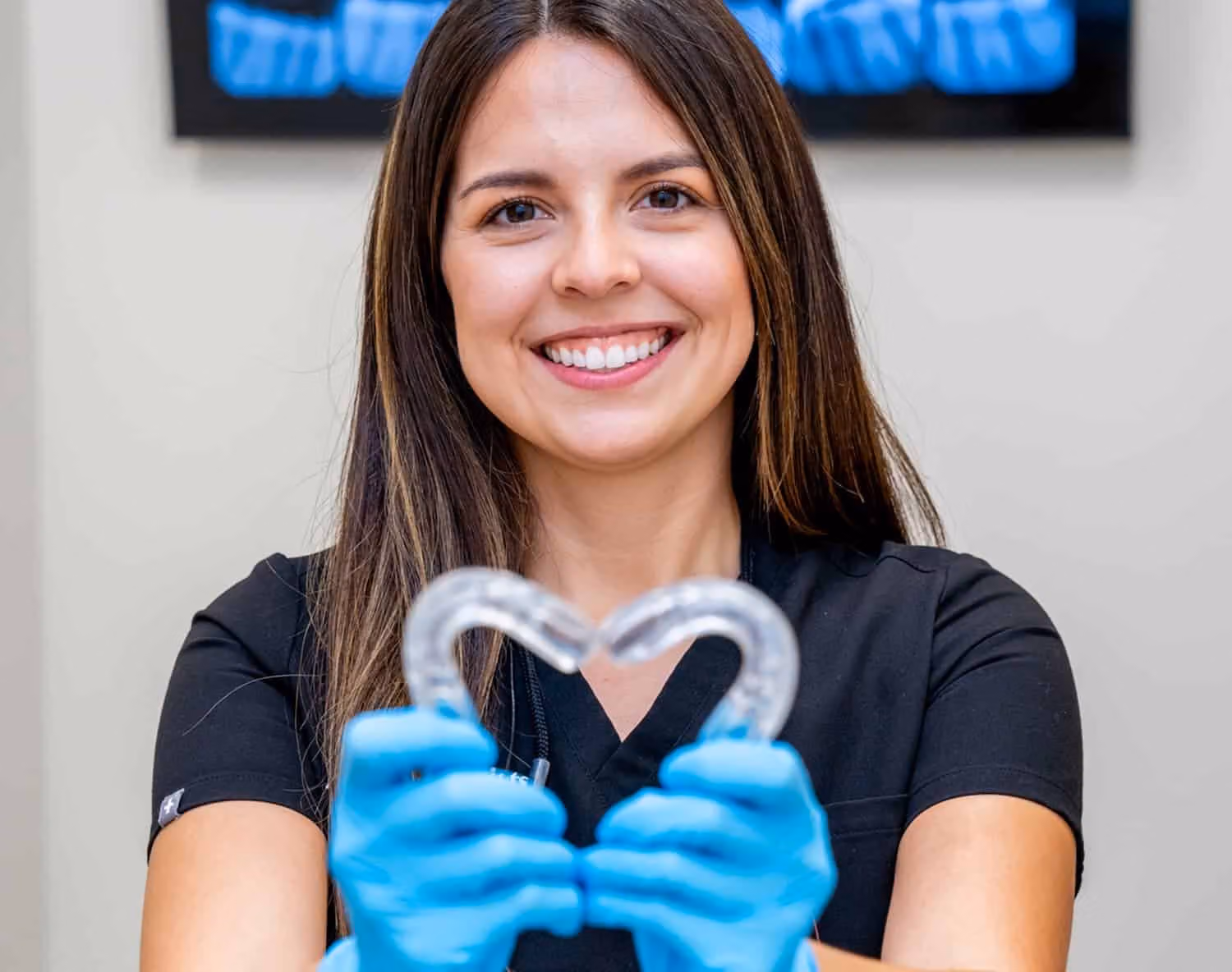 Dr. Amanda makes a heart with Invisalign trays