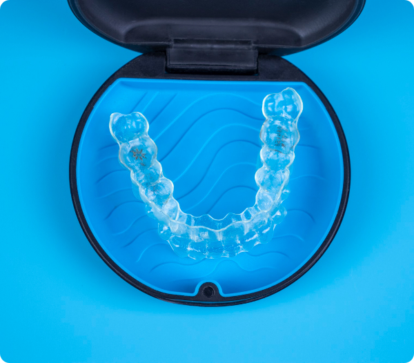Clear retainer inside an open blue case on a bright blue background.