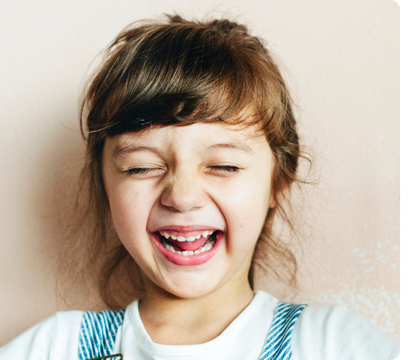 Child smiling while wearing a blue oral appliance.