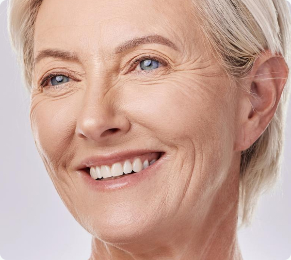 Smiling older woman showing natural-looking metal-free crowns.