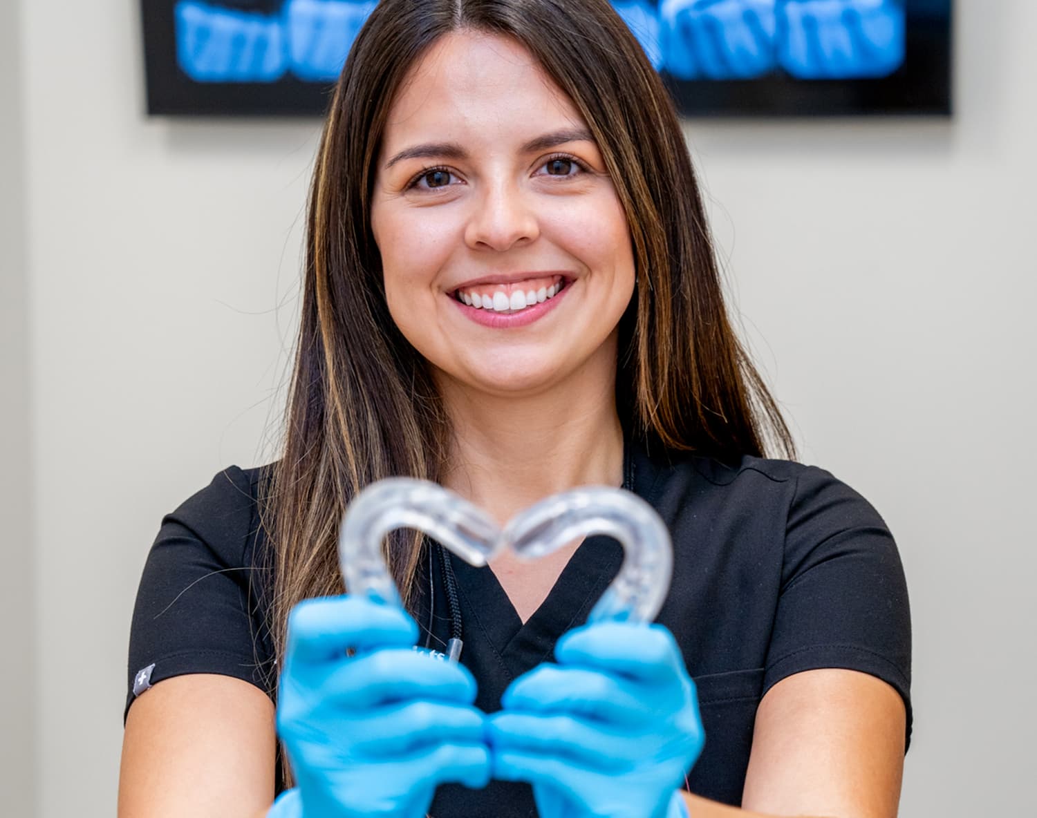 Dr. Amanda makes a heart with Invisalign trays