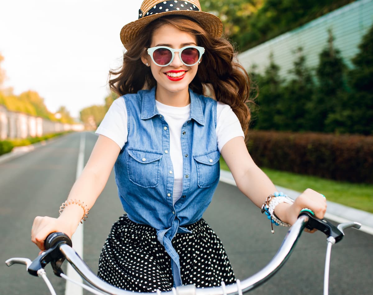 Smiling woman riding a bike in the sunshine