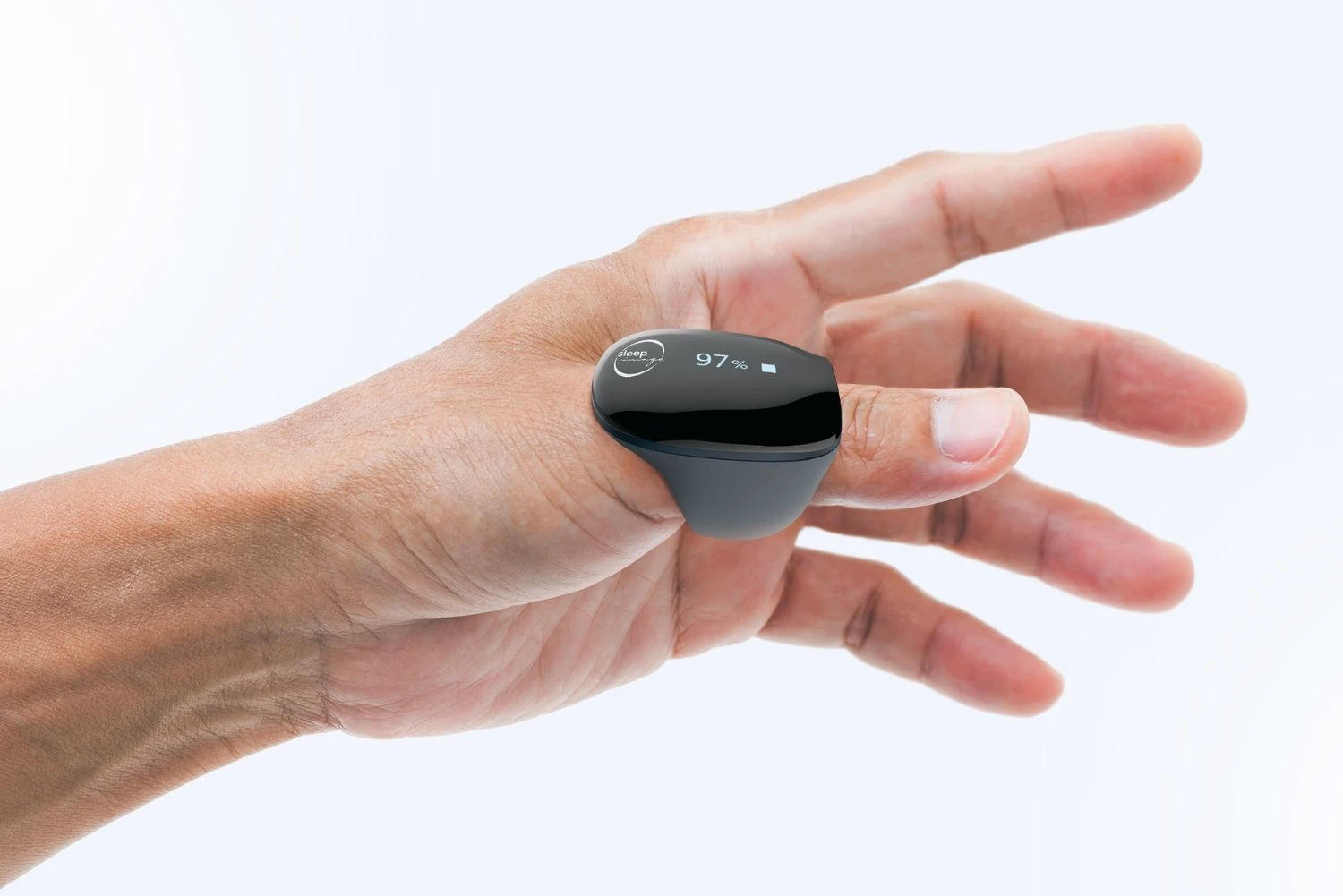 A person’s hand with a black pulse oximeter on the index finger displaying 97% oxygen saturation on a small screen.